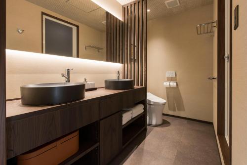 a bathroom with two sinks and a toilet at Hotel ZIZI Kyoto Gion in Kyoto