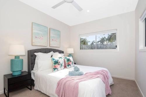 a white bedroom with a bed and a window at Park Avenue Townhouse Retreat Brisbane Sleeps 10 in Brisbane