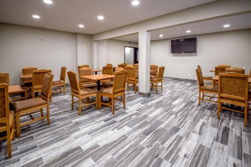 a conference room with tables and chairs and a flat screen tv at Days Inn & Suites by Wyndham Wisconsin Dells in Wisconsin Dells