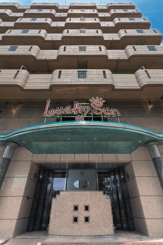 a tall building with a sign on top of it at Lucky Sun in Nishinomiya