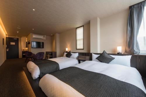 a hotel room with two beds in a room at Hotel ZIZI Kyoto Gion in Kyoto