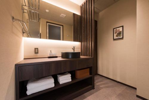 a bathroom with a sink and a mirror at Hotel ZIZI Kyoto Gion in Kyoto