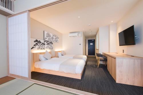 a hotel room with a bed and a flat screen tv at Hotel ZIZI Kyoto Gion in Kyoto