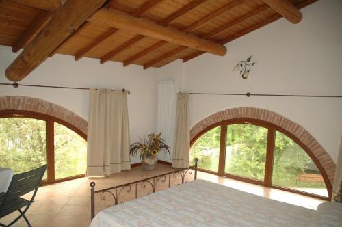 a bedroom with a bed and two large windows at Rose Rosse in Ca' di David