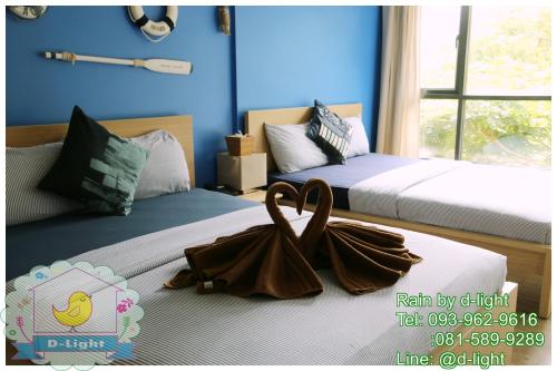 a bedroom with two beds with towels on them at Rain Cha-am Hua Hin by D-light in Cha Am