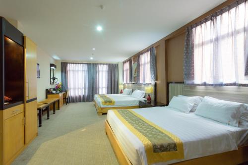 um quarto de hotel com duas camas e uma televisão de ecrã plano em Hallmark View Hotel em Malaca