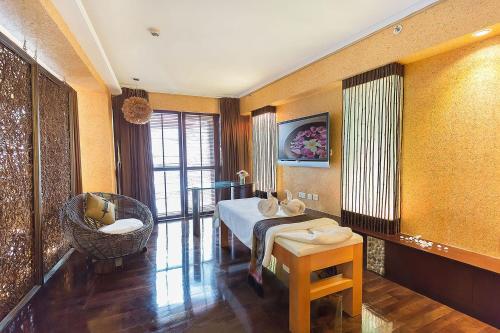 a bedroom with a bed and a chair in a room at Regal Airport Hotel in Hong Kong