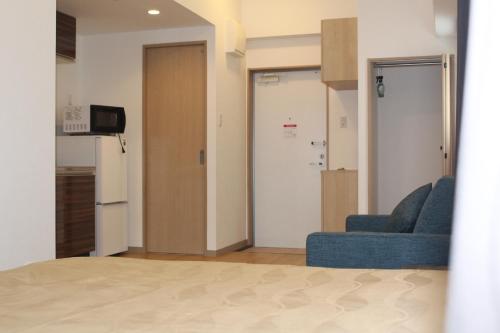 a living room with a blue couch and a door at M´s Stay Okinawa in Chatan