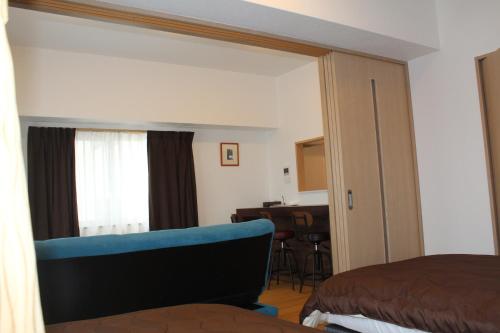 a bedroom with a mirror and a bed and a desk at M´s Stay Okinawa in Chatan