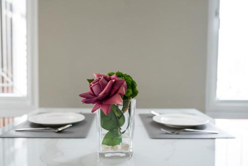a vase with a pink flower sitting on a table at SSB Residence in Phnom Penh