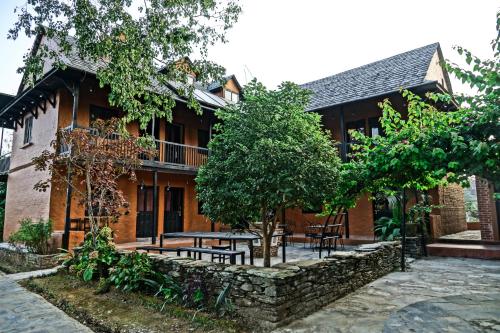 a building with tables and chairs in front of it at Depche Village Resort in Bandīpur