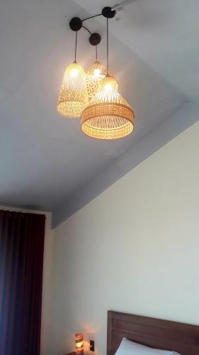 two lights hanging from a ceiling in a bedroom at Pink Tulip Hoi An in Hoi An