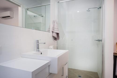a white bathroom with a sink and a shower at Albury Yalandra Apartment 5 in Albury