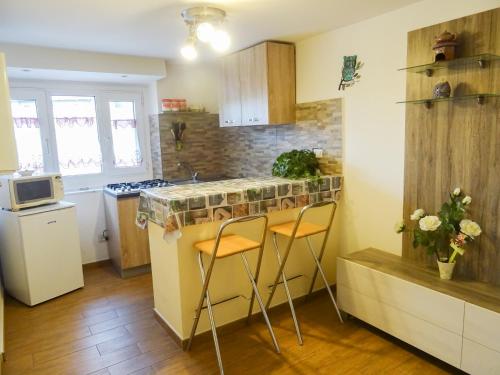 a kitchen with a counter and two stools in it at La piccionaia in Aosta