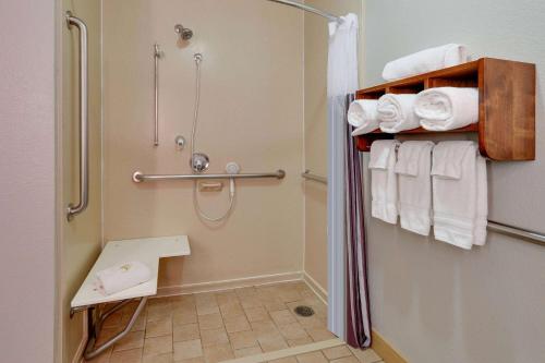 a small bathroom with a shower and towels at La Quinta by Wyndham Dallas Love Field in Dallas