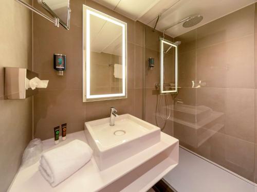 une salle de bain avec un lavabo, un miroir et une douche dans l'établissement Novotel Nice Centre Vieux Nice, à Nice