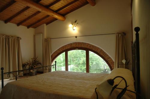 a bedroom with a large bed with a large window at Rose Rosse in Ca' di David