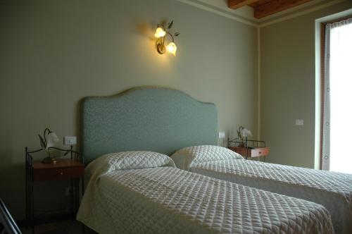 a bedroom with two beds and a blue headboard at Rose Rosse in Ca' di David