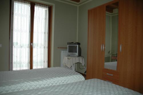 a bedroom with two beds and a tv and a mirror at Rose Rosse in Ca' di David