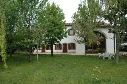 a white house with a yard with trees at Rose Rosse in Ca' di David