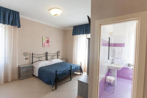 a bedroom with a bed and a bathroom with a sink at Villa Hotel Del Sole in Chiusi