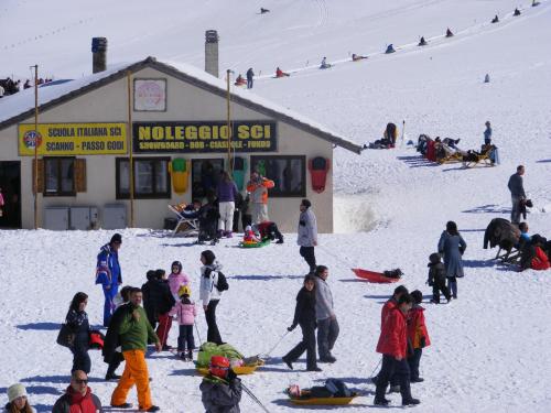 a group of people standing in the snow in front of a store at Rifugio Passo Godi in Scanno