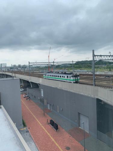 a train on a bridge with a train on it at Y's Hotel Asahikawa Ekimae in Asahikawa