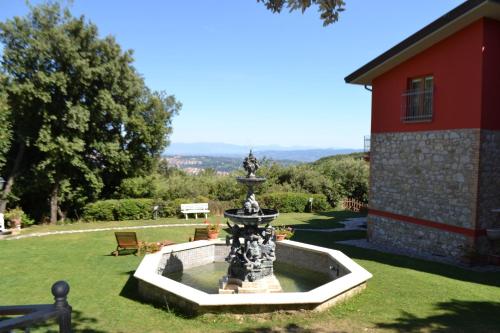 a fountain in the grass next to a red building at B&B Spring in Perugia