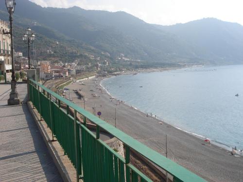 a view of a beach with a green fence at Villafiorita in Gioiosa Marea