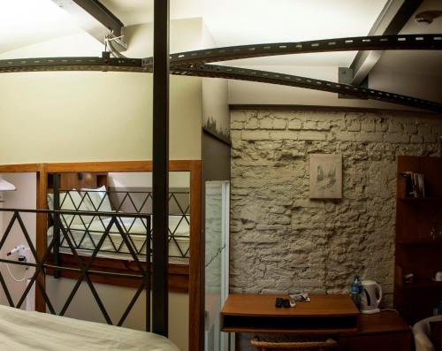 a loft bed in a room with a stone wall at Peradays in Istanbul