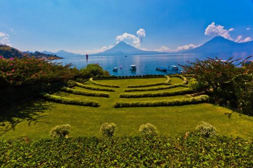 a garden with a view of a lake and a mountain at Hotel Atitlan in Panajachel