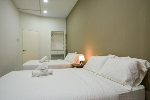 a bedroom with two beds with white sheets at DaMen Homestay @SubangHomeStay in Subang Jaya