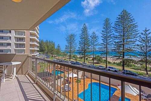 a balcony with a view of the beach and cars at Columbia Beachfront Apartments on Rainbow Bay in Gold Coast
