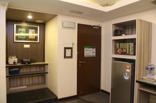 a hallway with a door and a refrigerator at Shamrock Guest House in Ipoh