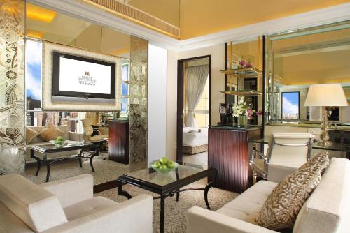 a living room with a couch and a television at Regal Hongkong Hotel in Hong Kong