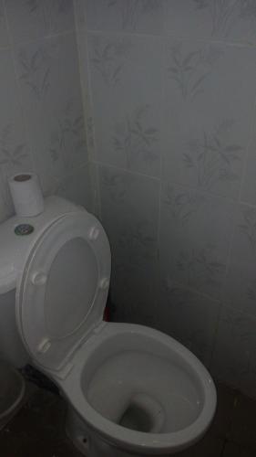 a bathroom with a toilet with a roll of toilet paper on it at JJ & JE Family House in Dar es Salaam