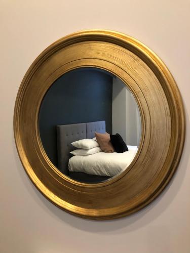 a mirror on a wall with a bed in a room at The Burlington Luxury Octagon Apartment in Dunedin