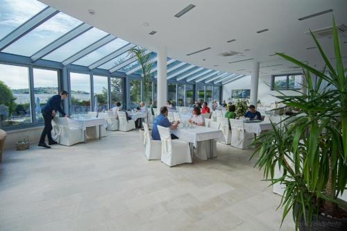a group of people sitting at tables in a building at Hotel Villa Radin in Vodice