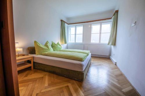 a bedroom with a bed with green pillows and a window at Ansitz Hofer in Fulpmes
