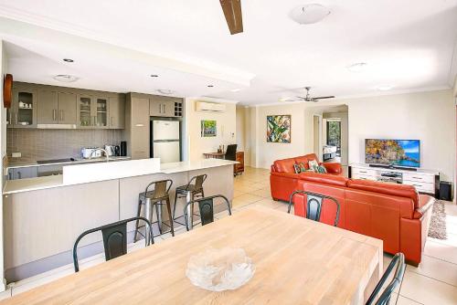 an open kitchen and living room with a table and chairs at Elysium Apartments in Palm Cove