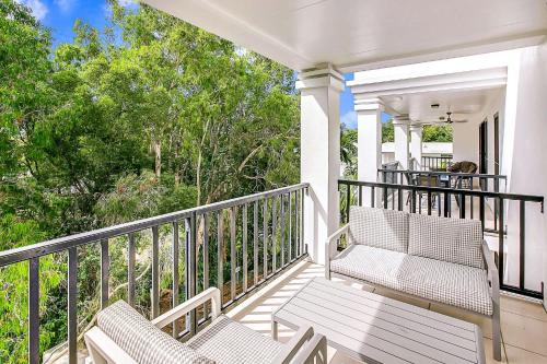 a porch with two chairs and a table at Elysium Apartments in Palm Cove