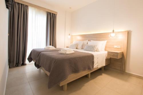 a bedroom with a large bed with towels on it at Porfyris Studios and Apartments in Karpathos Town