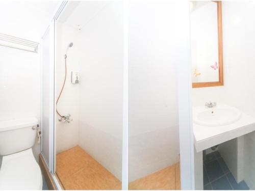 y baño con ducha, aseo y lavamanos. en Super OYO 1026 Hotel Lutana, en Sandakan