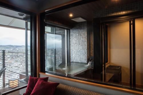 a room with a window with a couch and a view at Shoho in Matsumoto