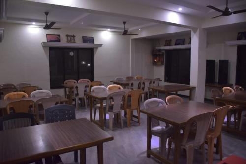 an empty classroom with tables and chairs and a chalkboard at Vamoose Gajanan in Malvan