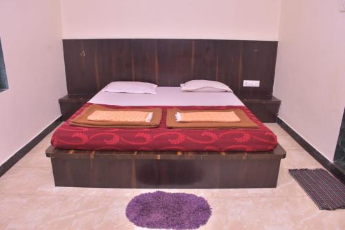 a bedroom with a bed with a wooden head board at Vamoose Gajanan in Malvan