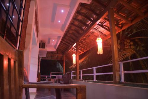 a restaurant with a wooden ceiling and chandeliers at Vamoose Gajanan in Malvan