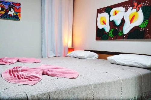 a bedroom with two beds with pink towels on them at Solar de Pipa Vip Confort - Spa Hidro Flat in Pipa
