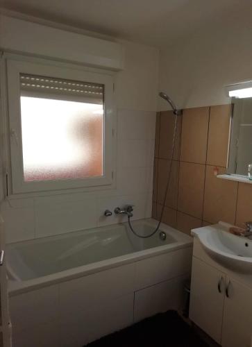 une salle de bain avec une baignoire et un lavabo dans l'établissement Les princes du golf Jerome numero 13 quartier pascal paoli Appartement, à Porto-Vecchio