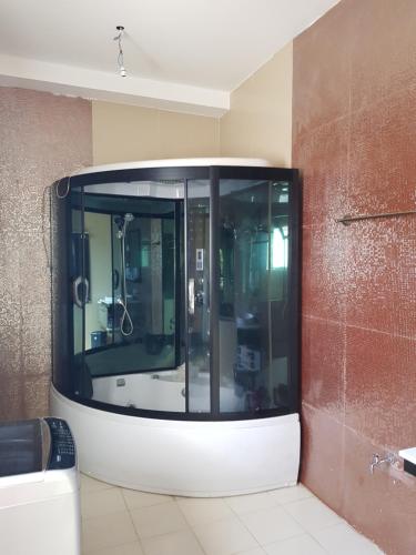 a bathroom with a glass shower in a room at Rohan's Residence in Kandana